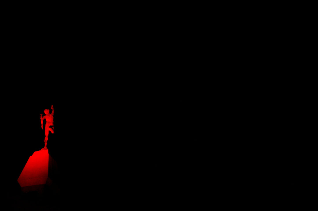 a person standing on top of a red object in the dark