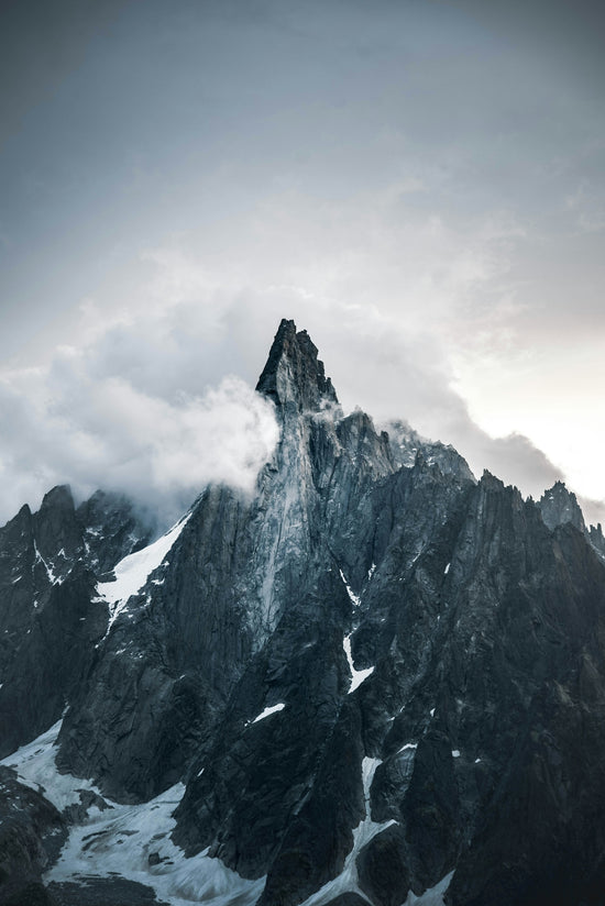 gray rocky mountain under white clouds during daytime