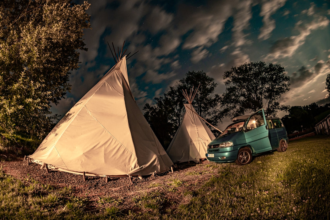 blue car parked beside white tent during night time