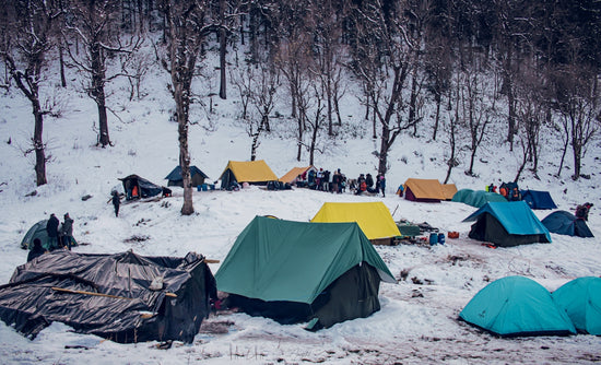 green tent on snow covered ground during daytime
