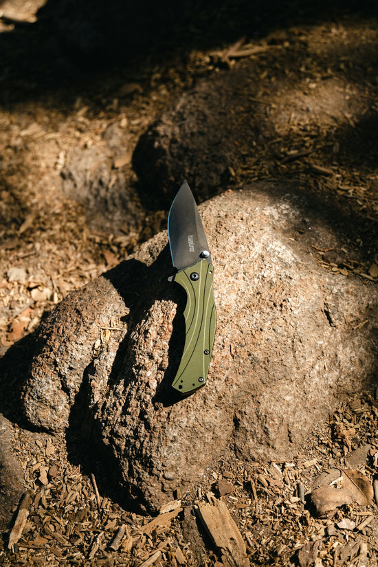 a knife stuck in a rock on the ground