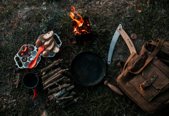 a campfire with a bunch of cooking utensils