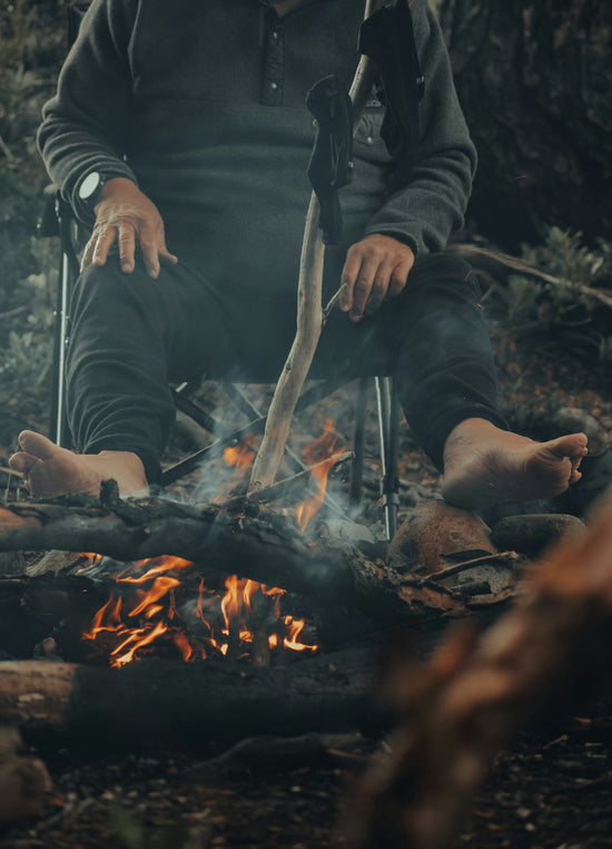a man sitting in a chair next to a fire