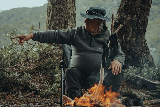 a man sitting in a chair next to a fire