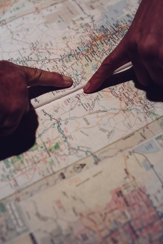two hands pointing at a map on a table