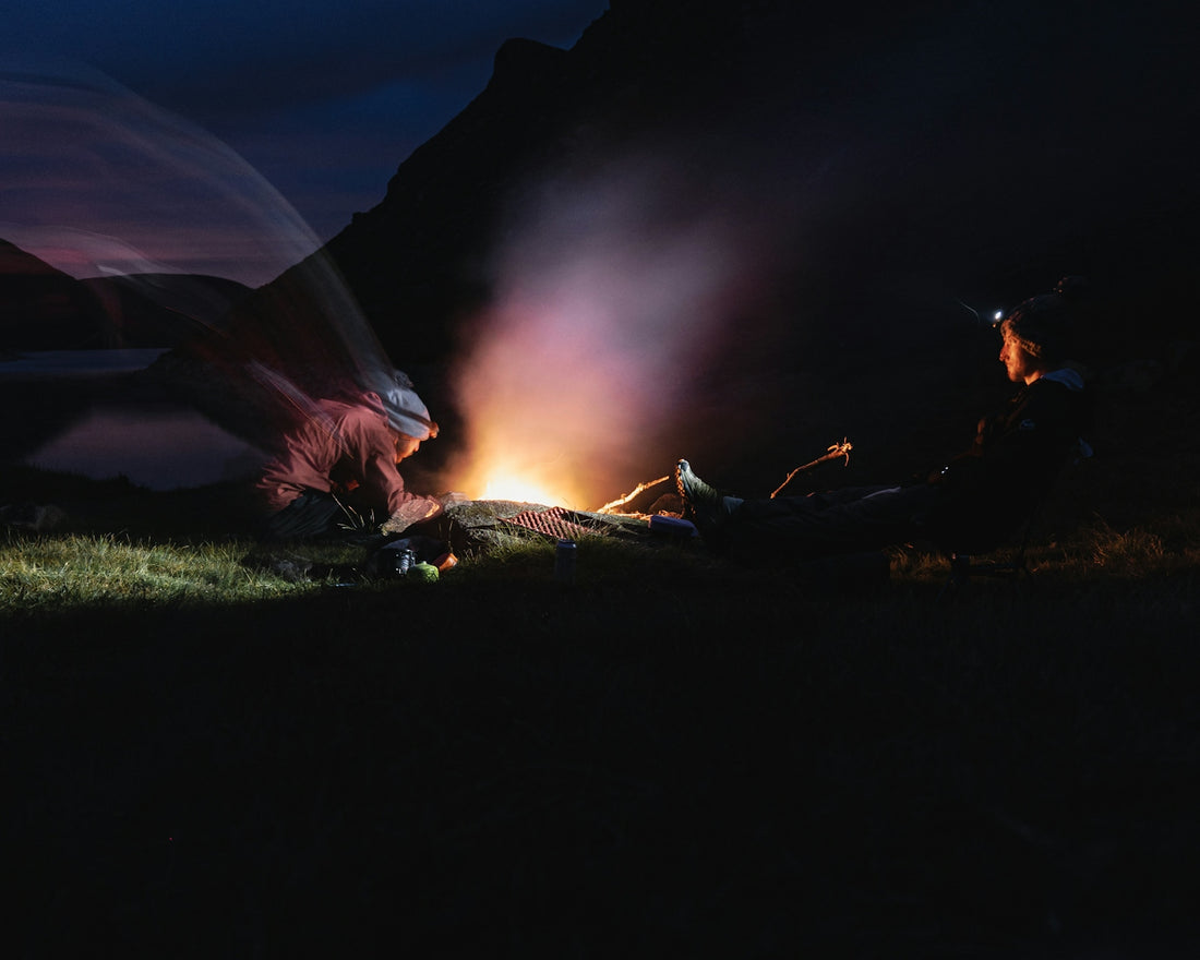 a couple of people sitting on top of a lush green field