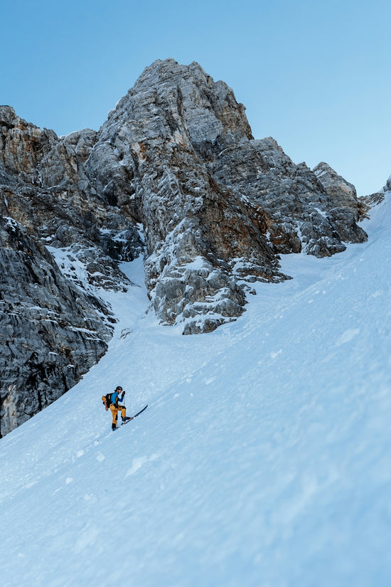 a man riding skis down a snow covered slope