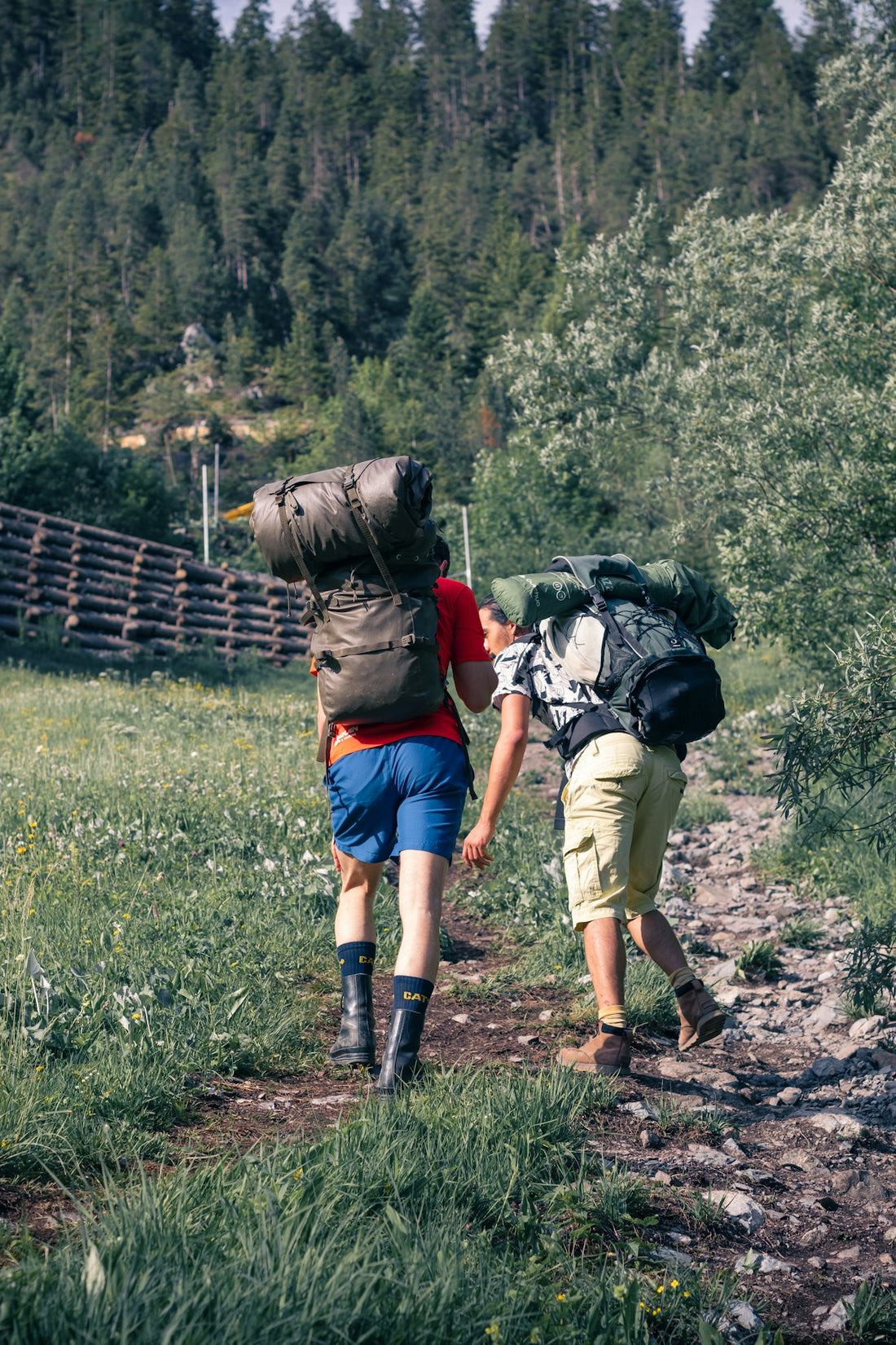 a couple of men walking down a dirt road