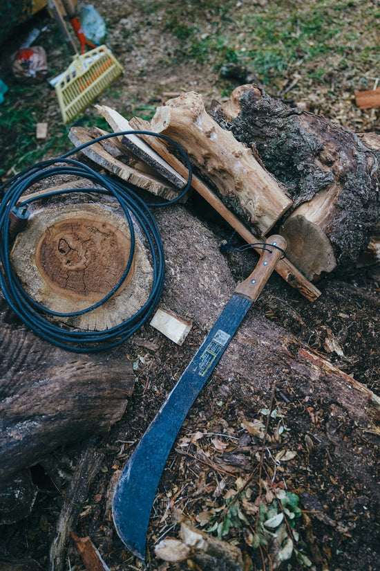 a wooden log with a knife and other tools