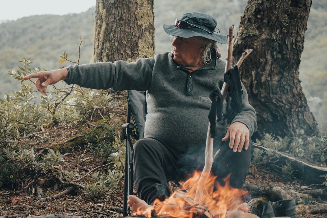 A man sitting in a chair next to a fire