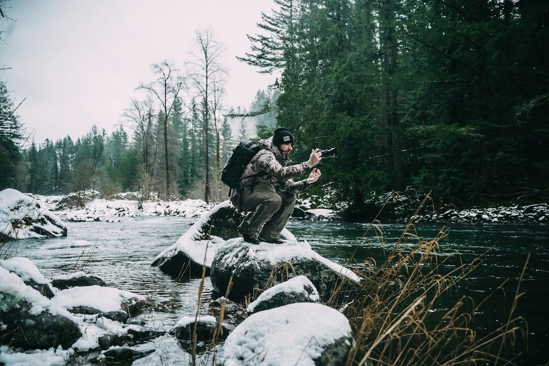 A man standing on a rock in the middle of a river