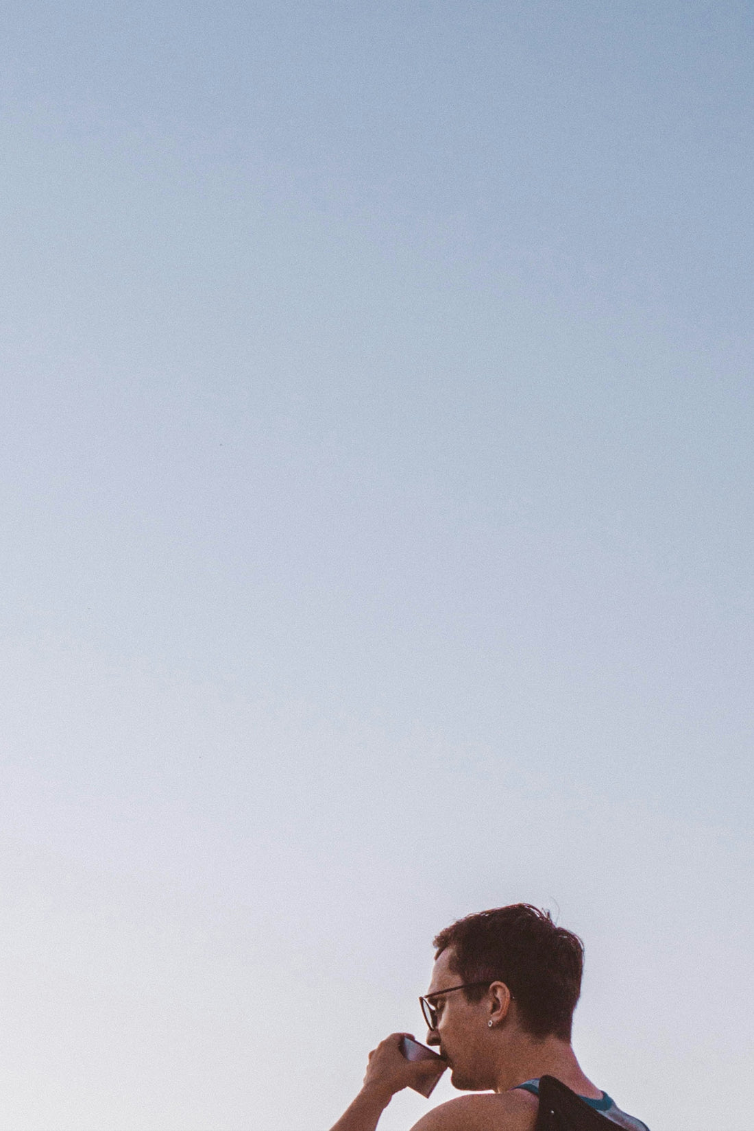 A man standing on a beach talking on a cell phone