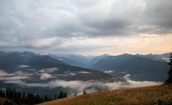 A view of a mountain range with clouds in the sky