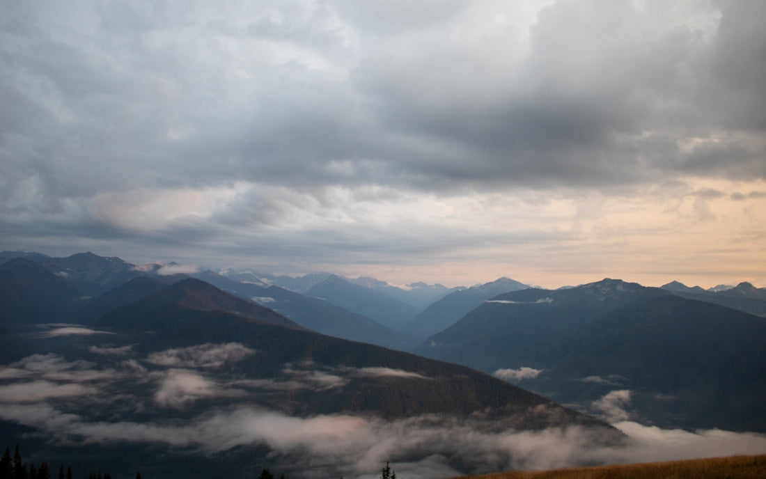 A view of a mountain range with clouds in the sky