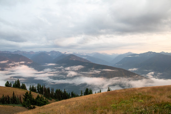 A scenic view of mountains and clouds in the distance