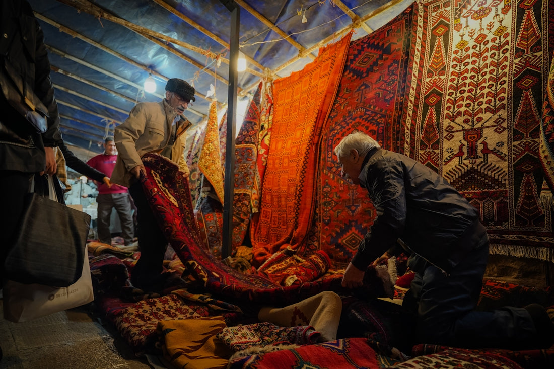 A group of people standing around a pile of rugs