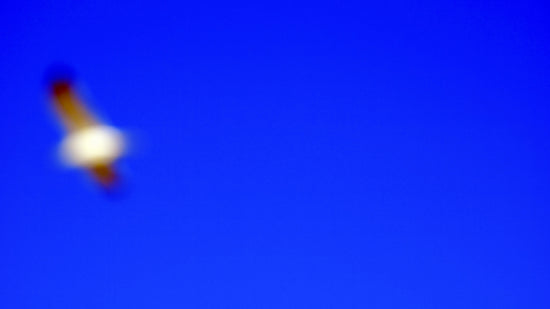 A blur shows a bright object against blue.