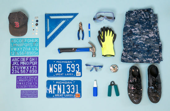 Tools, clothing, and license plates arranged flat lay