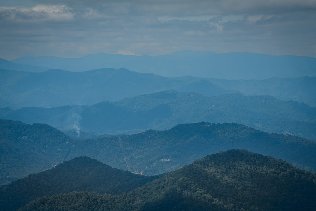 Layered blue mountains under a cloudy sky