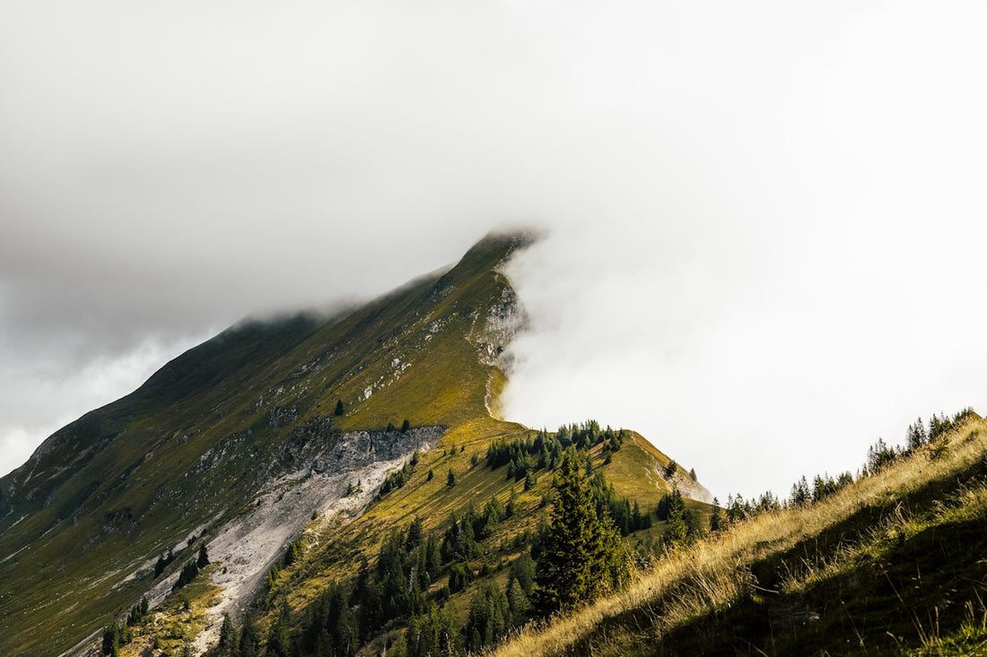Green mountain peak shrouded in clouds