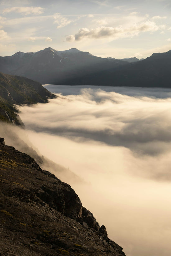 Mountains shrouded in fog above a misty lake