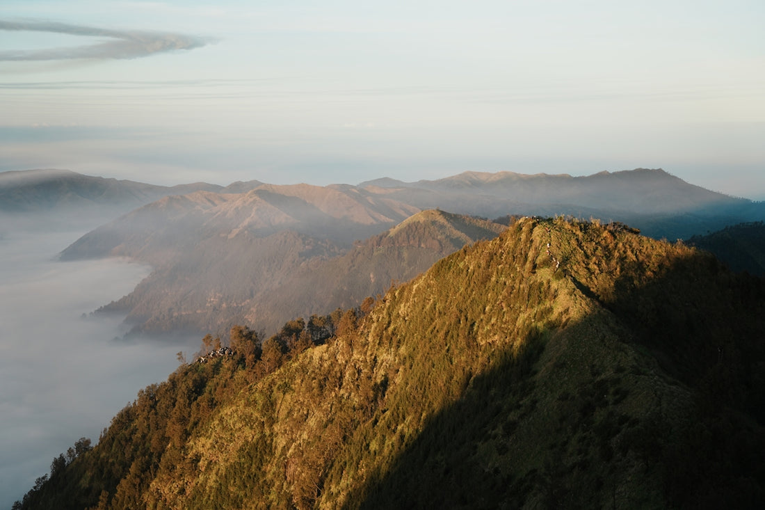 Majestic mountain peaks shrouded in fog during sunrise.