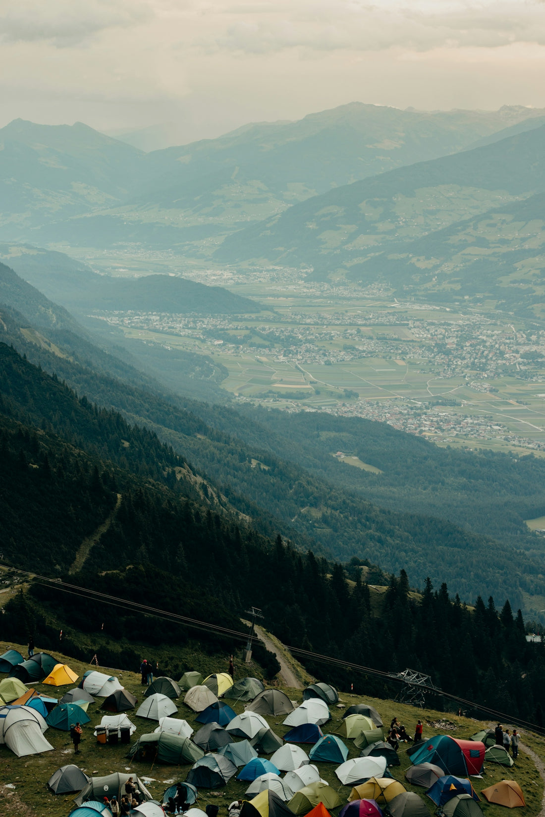 Tents pitched on a mountain slope overlooking a valley.