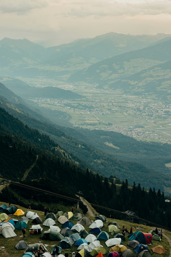 Tents pitched on a mountain slope overlooking a valley.