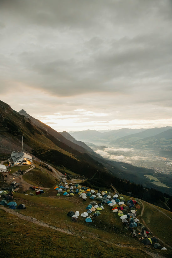 Mountain landscape with a campsite and distant valley at dawn.