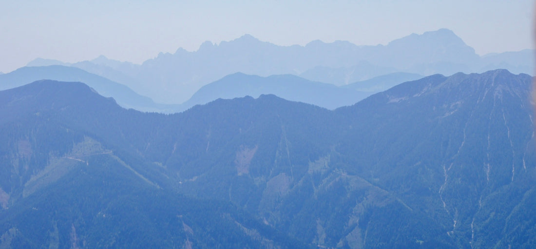 Layers of blue mountain ridges fading into the distance under a hazy sky